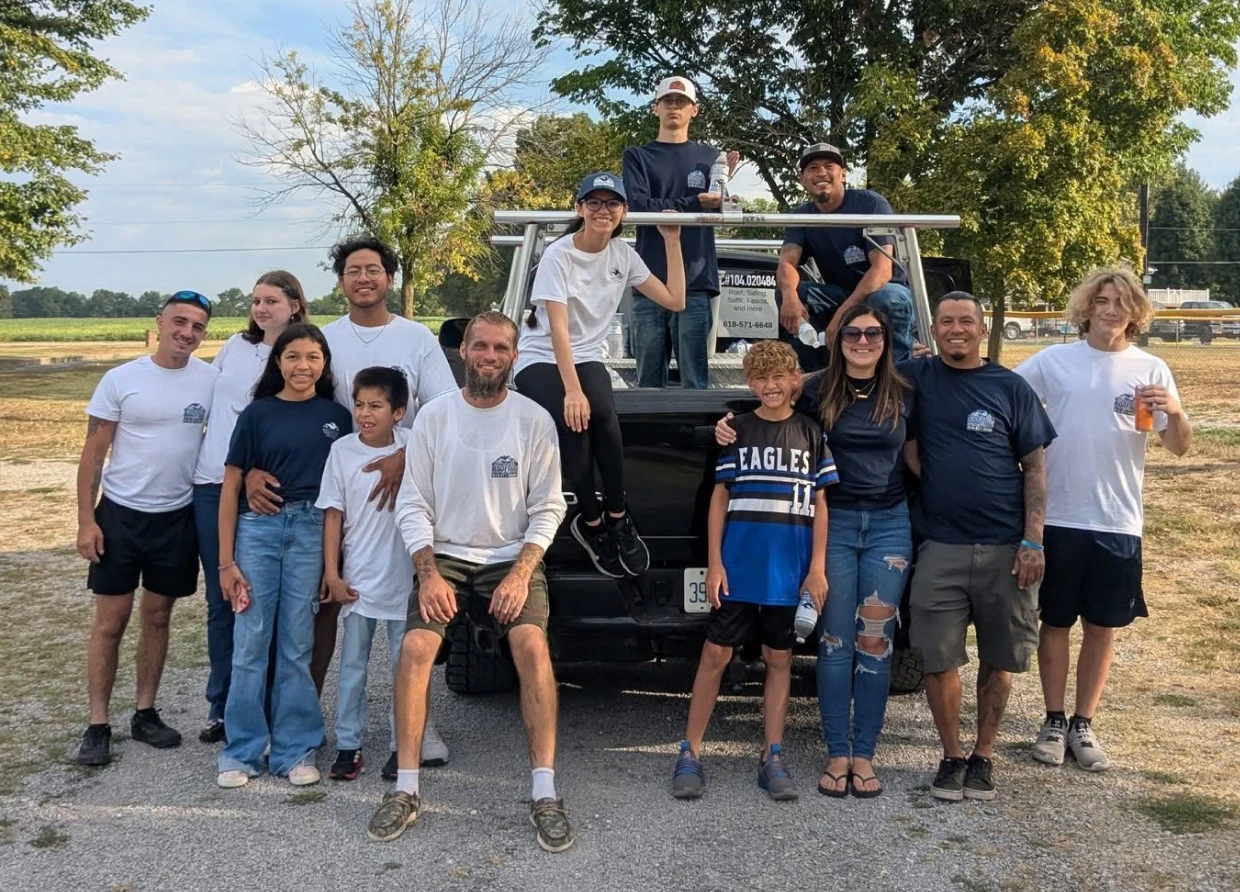 Group posing in front of a truck