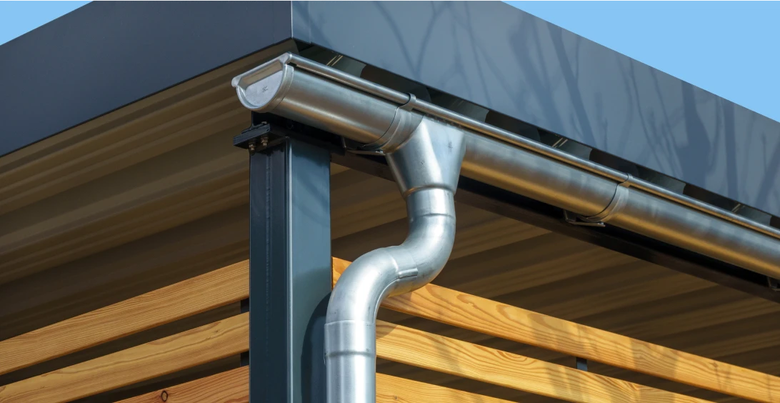 Metal gutter on modern wooden building